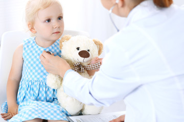 Doctor and a little blonde girl. Usual health exam. Medicine and healthcare concept