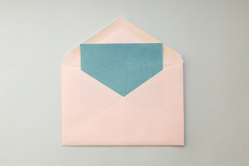 white envelope, blue blank card on a blue background. Minimal Flat lay