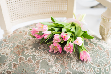 Pink tulips bouquet on vintage chair. Spring card