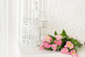Pink tulips bouquet and birdcage on white background. Spring card. Copy space