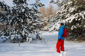 Happy man, traveler walking in the winter forest