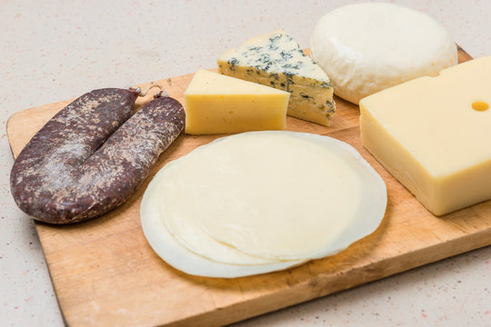 Different cheeses served on wooding cutting board
