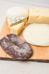 Different cheeses served on wooding cutting board