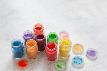 Bright colourful powdered pigments in glass bottles for Indian holi festival top view