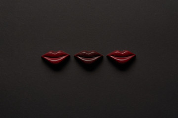 top view of tasty chocolate lips on black background with copy space