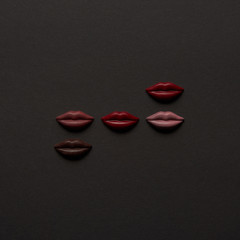 top view of sweet multicolored chocolate lips on black background
