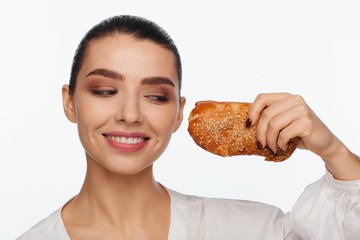 Portrait of a smiling beautiful woman with a sesame bun in her hand
