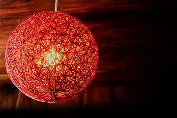 Obraz premium Close-up View of a red pendant lamp - twine lamp - glowing bulb