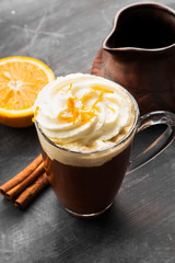 Autumn drink of coffee with orange juice and cream on dark background