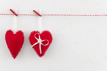 Two red felt hearts hanging on the rope fixed by clothespins isolated on white background. Valentines day concept. I love you. Copy space