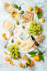 Foto op Plexiglas Cheese platter with different cheeses, grapes, nuts, honey. Appetizers table with antipasti snacks. Cheese variety board over white marble background. Top view, flat lay © sveta_zarzamora
