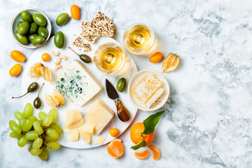 Cheese platter with different cheeses, grapes, nuts, honey. Appetizers table with antipasti snacks....