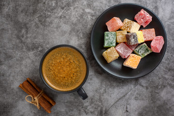 Turkish delight and cup of coffee on grey background. Top view