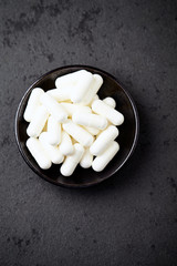 Creatine capsules. Bodybuilding food supplement on black stone background. Top view. copy space. 