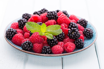 Fresh raspberries in a plate on a  vintage background.