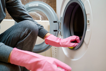 Image of woman 's hand in pink rubber glove washing washing machine - obrazy, fototapety, plakaty