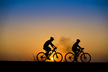 Obraz na płótnie Canvas Silhouette of cyclist with mountain bike on beautiful sunset time.