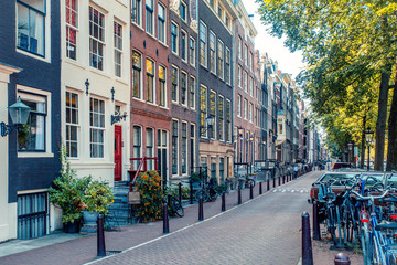 Street scene from Amsterdam with typical architecture of row of buildings alongside canal with non...