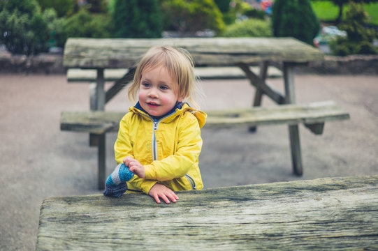 Little toddler sitting on bench outside