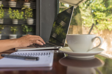 Side view of young man hand using laptop