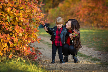 Naklejka na ściany i meble happy family mother and child little daughter running and playing on autumn walk