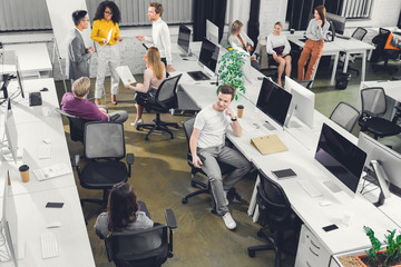 high angle view of professional young business people working with papers and computers in open...