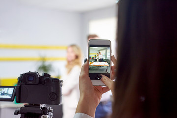 Woman taking photo of business partners actors