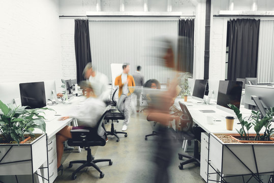 Contemporary Open Space Office Interior With Blurred Coworkers In Motion