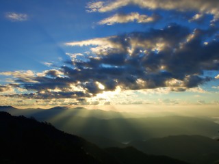 The dawn golden light that shine inside the cloud to the green mountain. A very nice moment to see in the morning