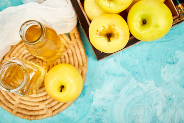 Glass Bottle of apple organic vinegar on blue background.