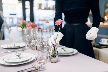 Waitress against empty tableware, table setting