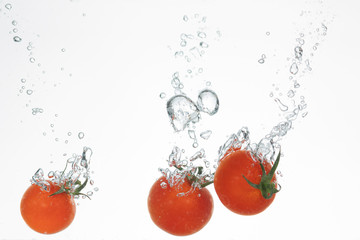 Rote Tomaten splashen in Wasser