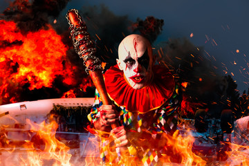 Crazy bloody clown, airplane in fire on background