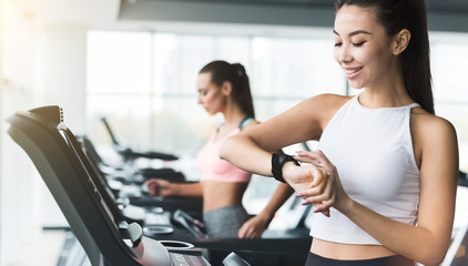Fototapeta premium Woman checking heart rate, running on treadmill