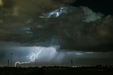 A powerful lightningbolt strikes in the earth from a dramatic thundercloud