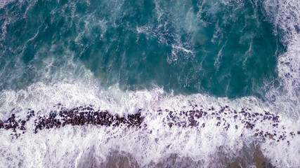 Massive Storm waves hitting and passing a wave breaker - Tsunami pattern of sea water flooding and not retreating.