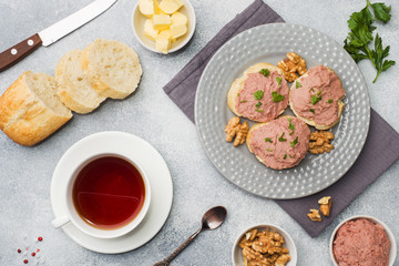 Breakfast on the table. Chicken pate and butter sandwiches. Cup of tea