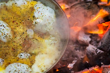 Fototapeta na wymiar breakfast in the forest, eggs are fried in a pan