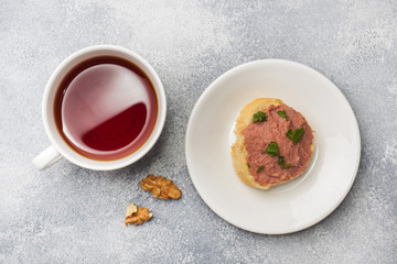 Breakfast on the table. Chicken pate and butter sandwiches. Cup of tea