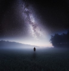 Dreamy surreal landscape with starry night sky and man silhouette - 243333549
