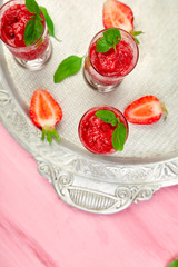 Summer refreshing strawberry sorbet, slush granita drink in serving glasses on silver tray.