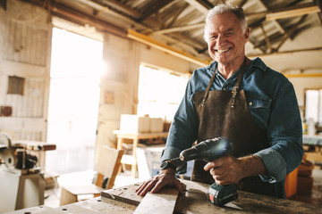 Senior male carpenter working at his workshop