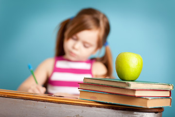 Little Girl Writing While in School Desk