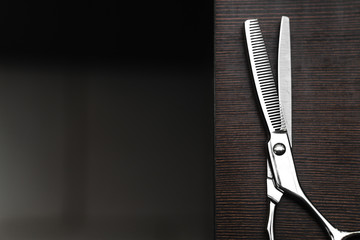 scissors for highlighting on a dark wooden table. Hairdressing Workspace. Work place for hairdresser. Professional Salon Supplies. Hair. Place for text. copy space