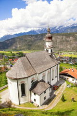 Fototapeta na wymiar Top view of the Heiliger Antonius von Padua church surrounded by green meadows and hills.Austria.