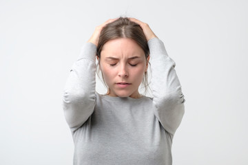 Young stressed woman holding head in hands