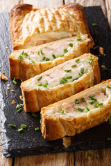 Traditional puff pastry pie stuffed with salmon with cheese close-up. vertical