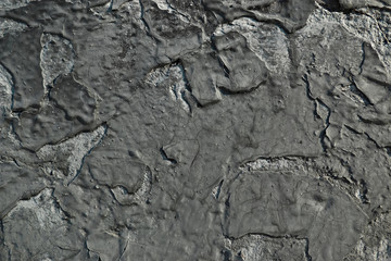 Peeling black paint on a concrete wall. Abstract background. Close-up