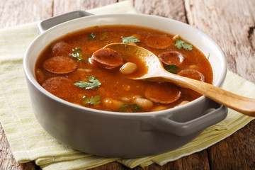 Breton beans with sausage in tomato sauce close-up in a saucepan. horizontal