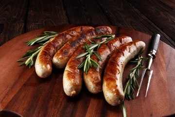 Wandcirkels aluminium Grilled sausages with spices on a wooden table - Home-made Pork Sausages © beats_